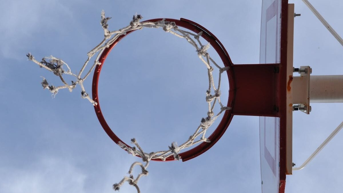 Basketballkorb mit zerfetztem Netz gegen einen klaren Himmel