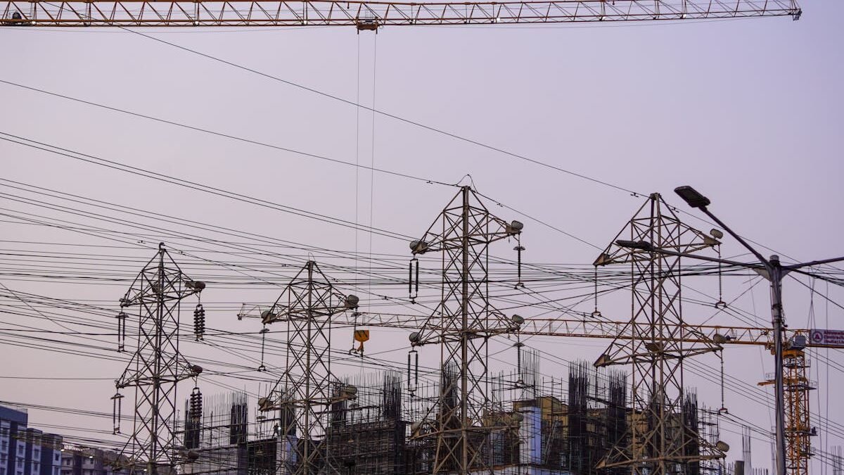 Baustelle mit Kränen und Stromleitungen während der Abendstunden