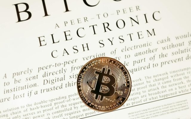 Nahaufnahme einer Bitcoin-Münze auf dem Whitepaper der Kryptowährung
