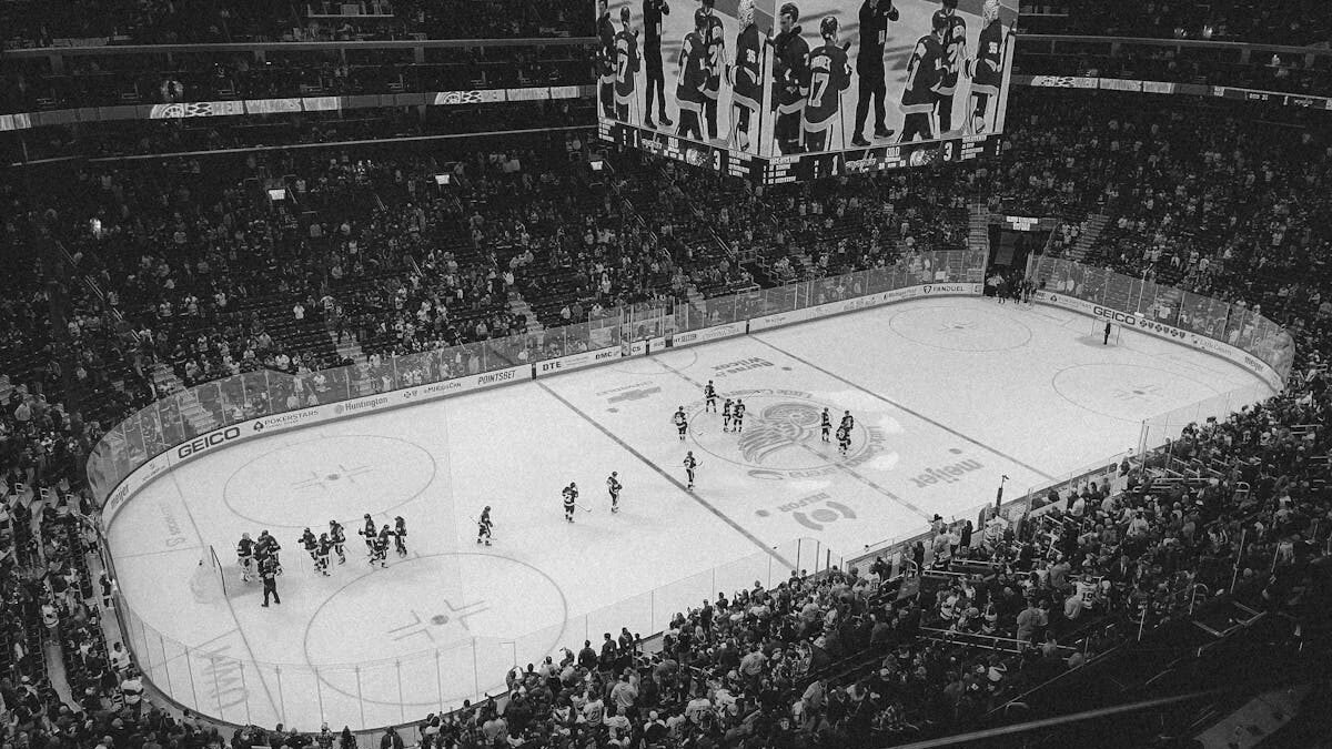Schwarz-Weiß-Luftaufnahme eines spannenden Eishockeyspiels mit vollem Publikum in einer Arena