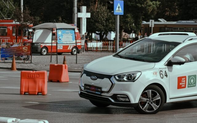 Dynamisches Elektroauto-Rennen in einer städtischen Umgebung mit Verkehrskegeln und Stadtkulisse