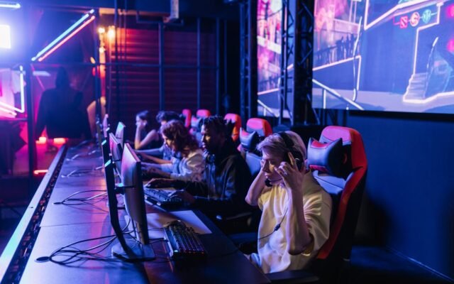 Konzentrierte Gamer in einer High-Tech-Arena treten intensiv gegeneinander an und zeigen E-Sport-Leidenschaft