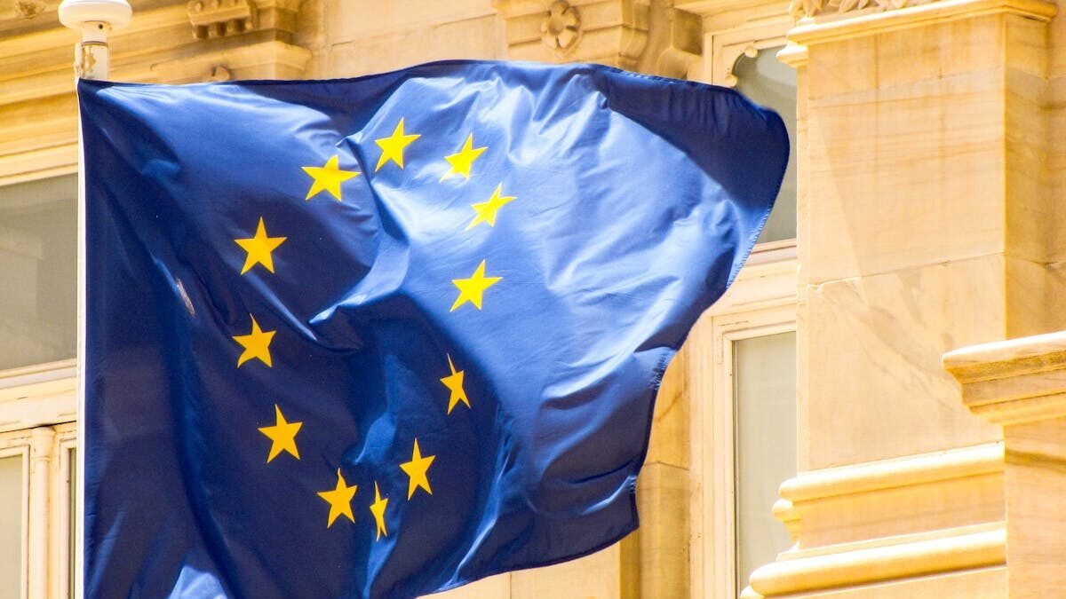 Leuchtende Flagge der Europäischen Union vor historischer Architektur