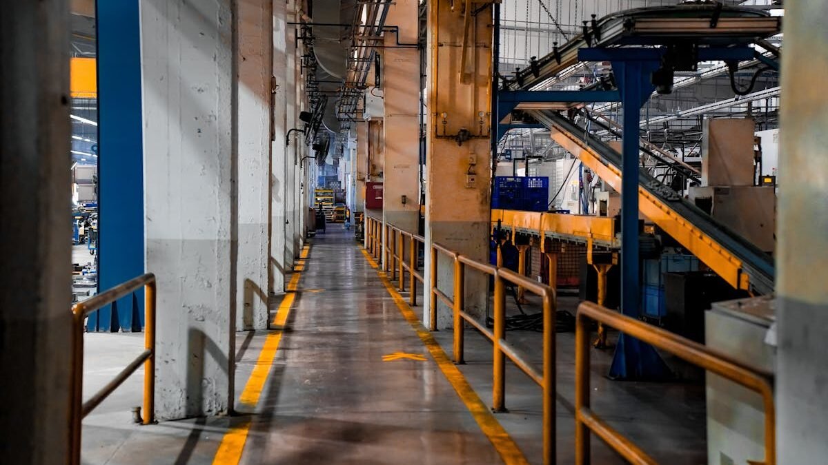Weite Ansicht eines modernen Fabrikinneren mit Industriemaschinen und Förderbandsystemen