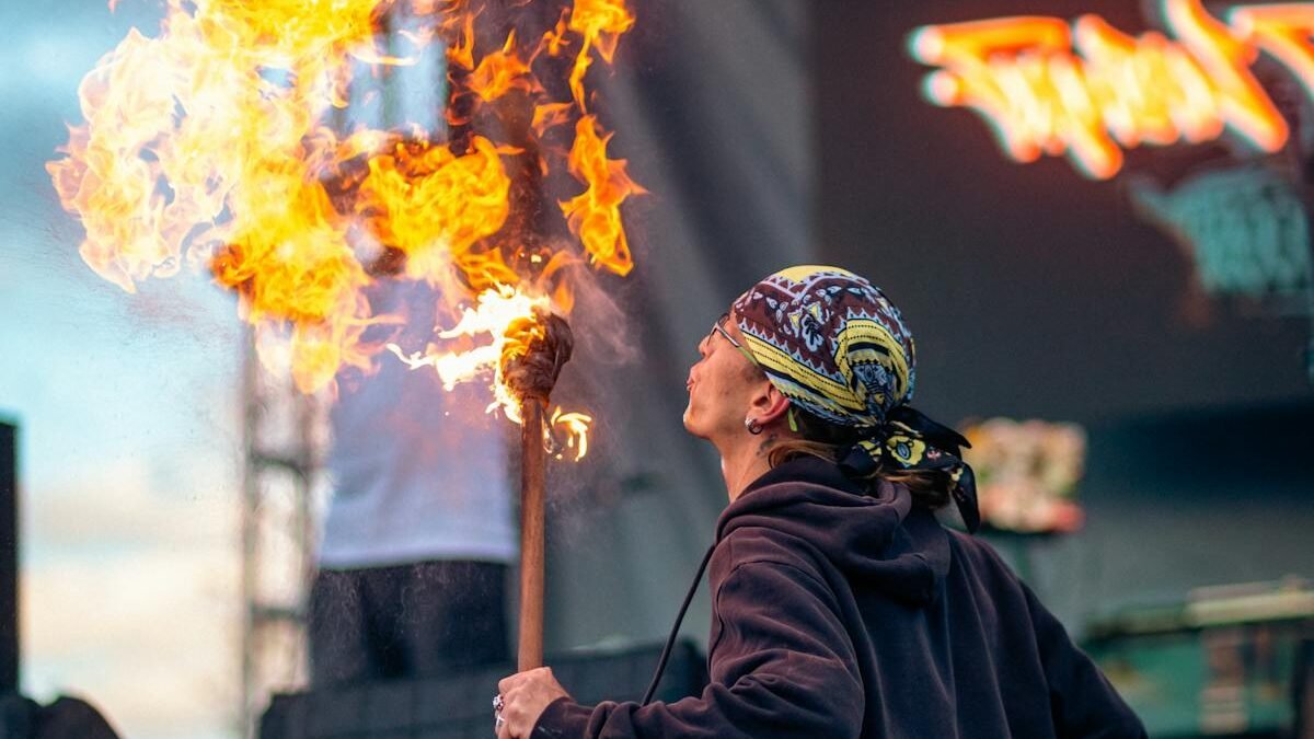 Ein faszinierender Straßenkünstler zeigt Feuerspucken mit einer brennenden Fackel