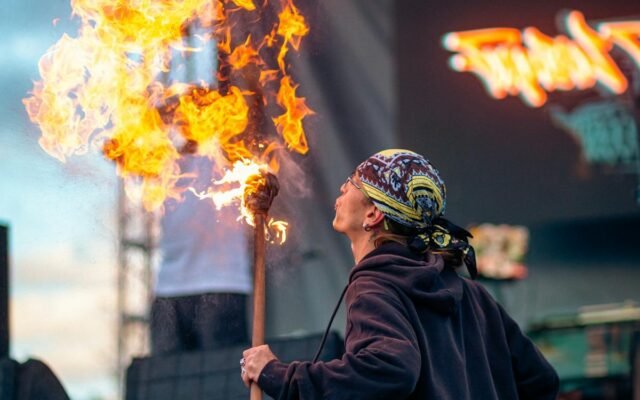 Ein faszinierender Straßenkünstler zeigt Feuerspucken mit einer brennenden Fackel