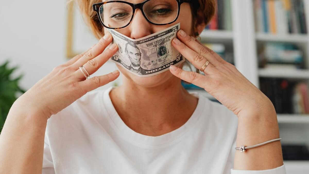 Eine Frau mit Brille nutzt einen Dollarschein als Maske