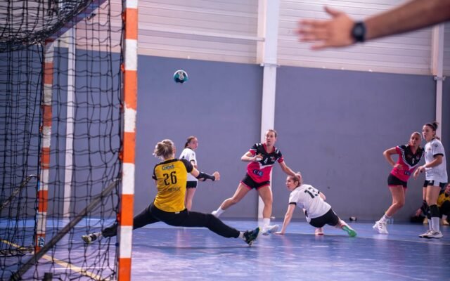 Dynamische Action-Aufnahme eines Handballspiels der Frauen mit Spielerinnen mitten in der Bewegung