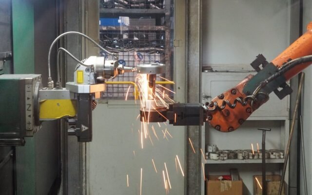 Ein Roboterarm beim Schweißen in einer Industrieumgebung