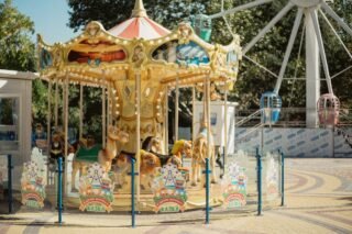 Farbenfrohes Karussell in einem Freizeitpark im Freien mit Tierfiguren in sommerlicher Umgebung
