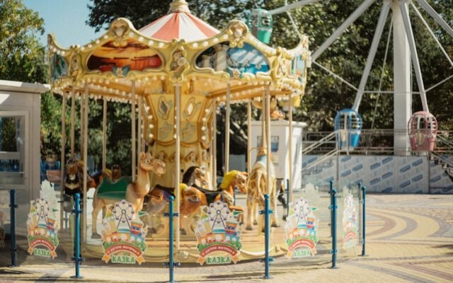 Farbenfrohes Karussell in einem Freizeitpark im Freien mit Tierfiguren in sommerlicher Umgebung