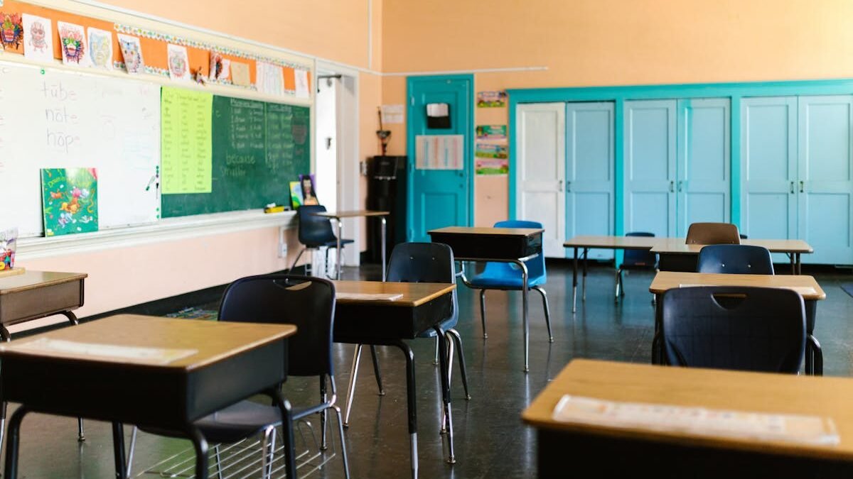 Helles und farbenfrohes leeres Klassenzimmer mit Schreibtischen