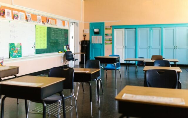 Helles und farbenfrohes leeres Klassenzimmer mit Schreibtischen