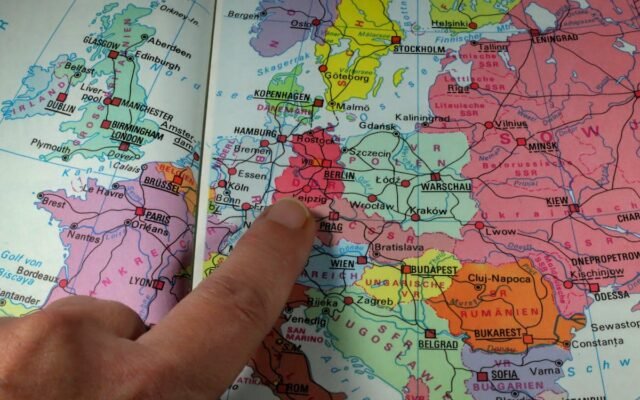 Ein Finger zeigt auf Berlin auf einer farbenfrohen politischen Landkarte von Europa aus der Zeit des Kalten Krieges