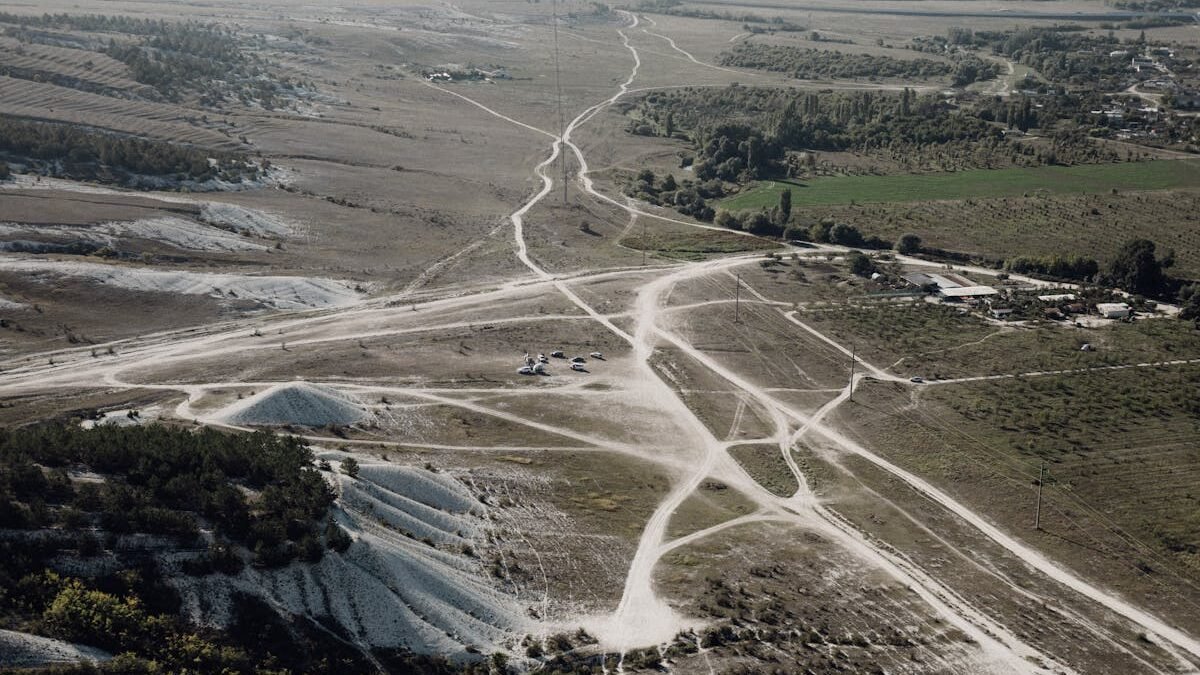 Luftaufnahme einer kargen Landschaft mit sich kreuzenden Feldwegen und natürlichen Mustern