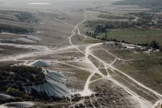 Luftaufnahme einer kargen Landschaft mit sich kreuzenden Feldwegen und natürlichen Mustern