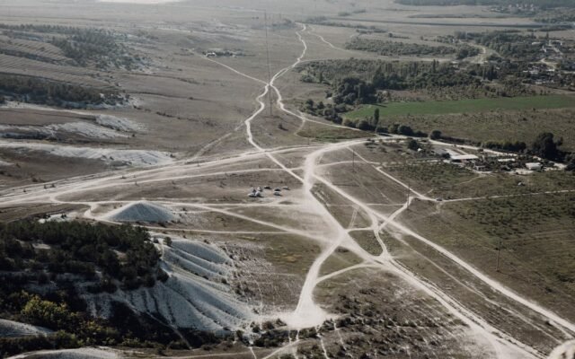 Luftaufnahme einer kargen Landschaft mit sich kreuzenden Feldwegen und natürlichen Mustern