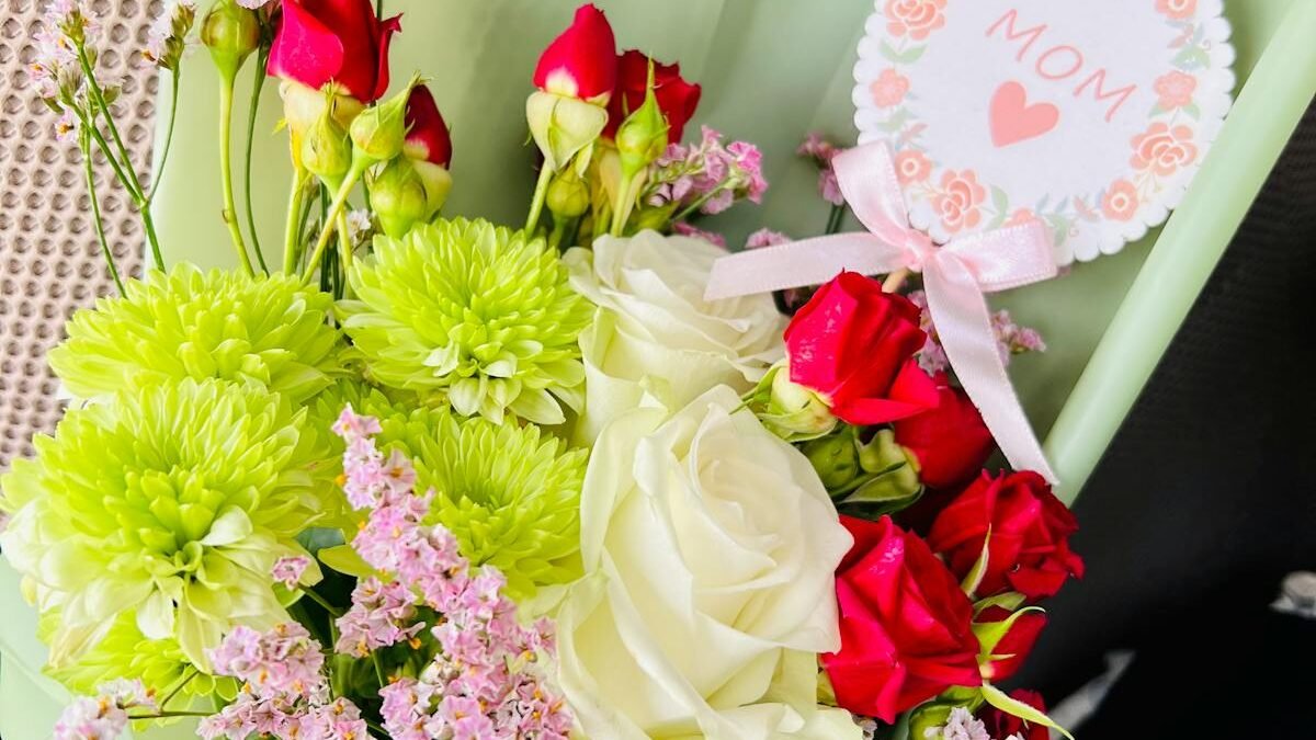 Schöner Strauß aus Rosen und gemischten Blumen mit einer Muttertagskarte