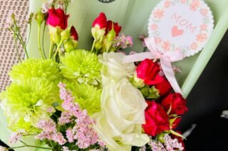 Schöner Strauß aus Rosen und gemischten Blumen mit einer Muttertagskarte