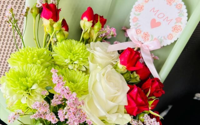 Schöner Strauß aus Rosen und gemischten Blumen mit einer Muttertagskarte