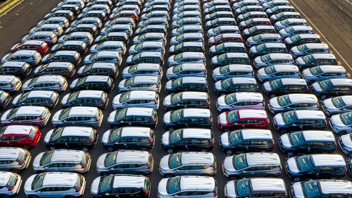 Luftaufnahme von Neuwagen in Reihen auf einem Werksgelände