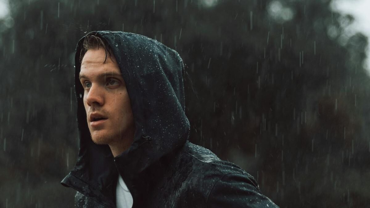 Stimmungsvolles Porträt eines Mannes im Freien bei Regen