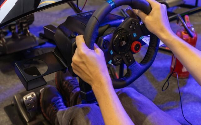 Mann vertieft in ein virtuelles Rennspiel mit realistischem Simulator-Setup inklusive Lenkrad und Pedalen