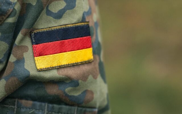 Nahaufnahme einer deutschen Militär-Tarnuniform mit Flaggenaufnäher