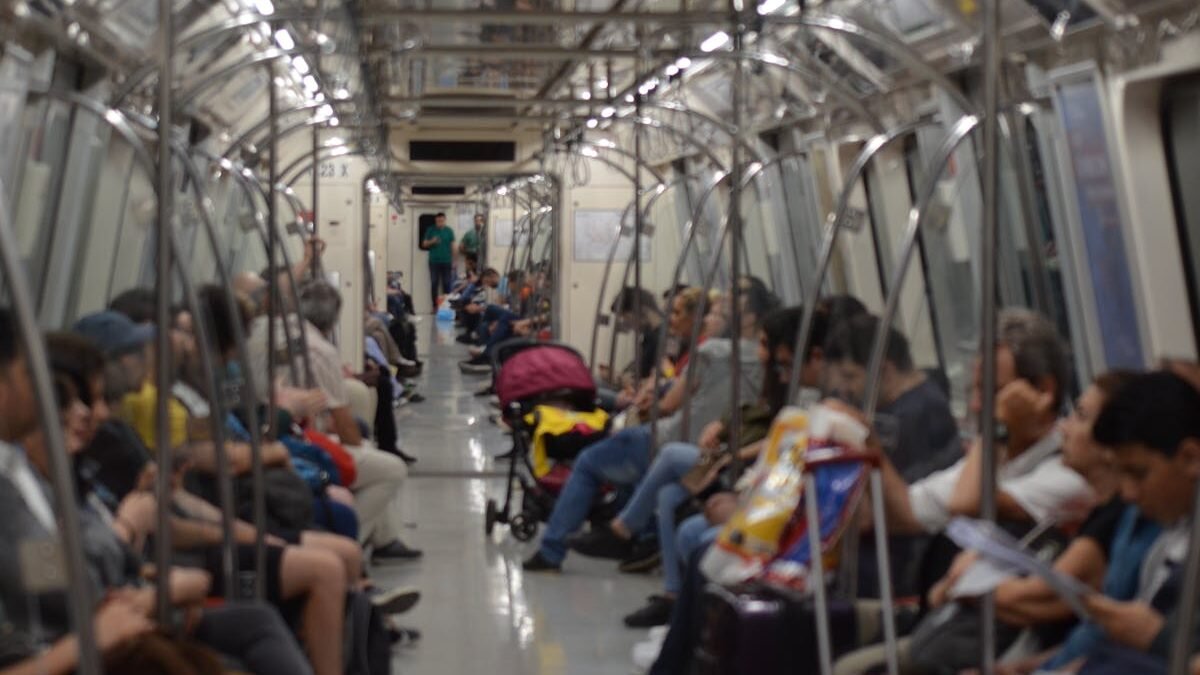 Ein überfüllter U-Bahn-Wagen mit verschiedenen Pendlern in einem Stadtgebiet