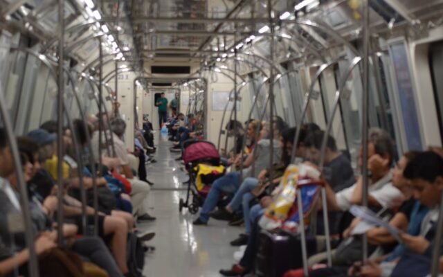 Ein überfüllter U-Bahn-Wagen mit verschiedenen Pendlern in einem Stadtgebiet