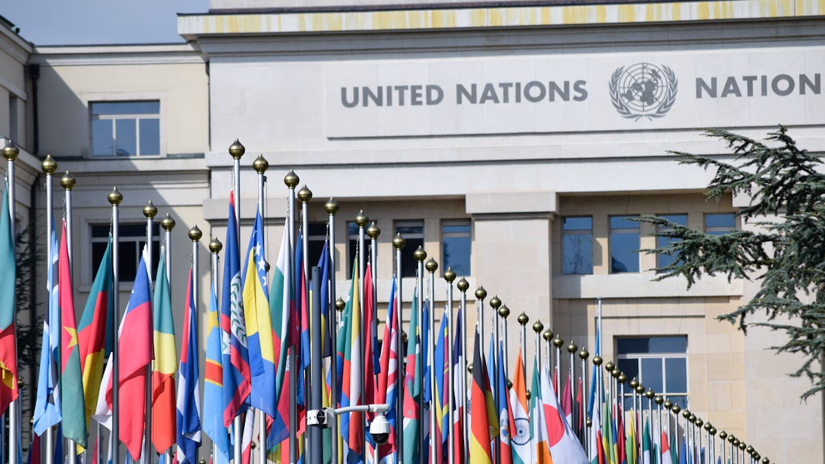 Bunte Flaggen vor dem Büro der Vereinten Nationen in Genf als Symbol für globale Einheit