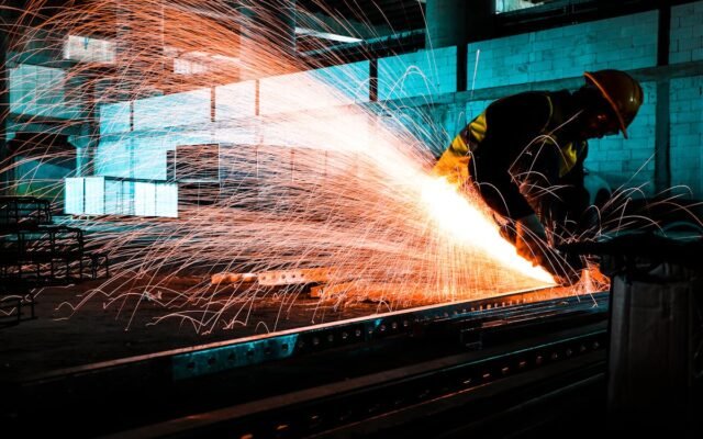 Ein Industriearbeiter verwendet einen Winkelschleifer zum Schneiden von Stahl